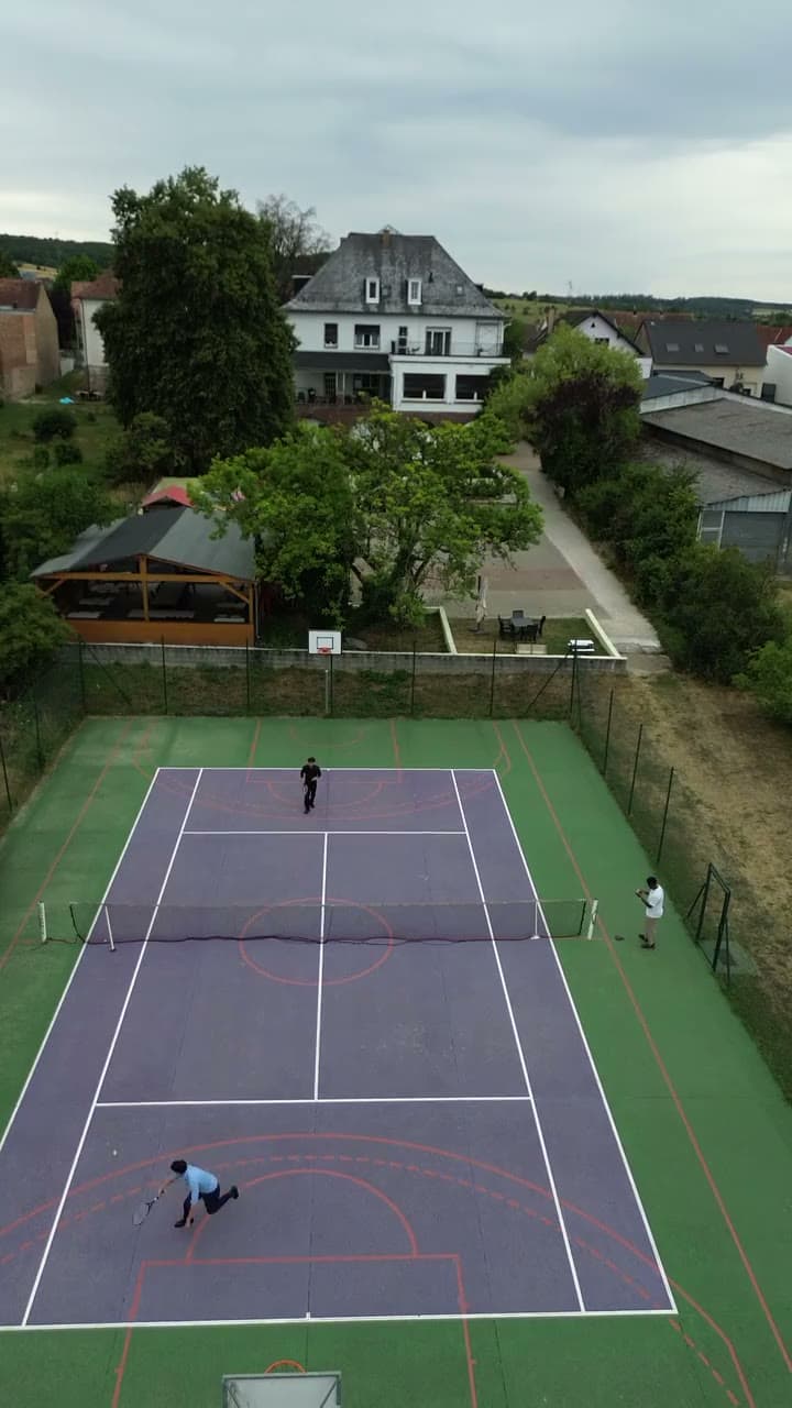 Vue aérienne d’un manoir avec court de tennis privé