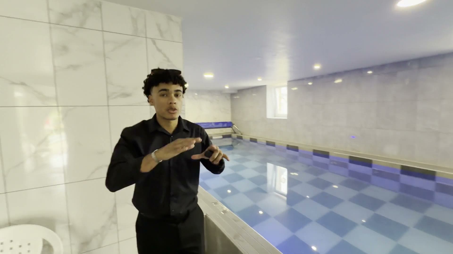 Notre présentateur détaille la piscine intérieure face caméra