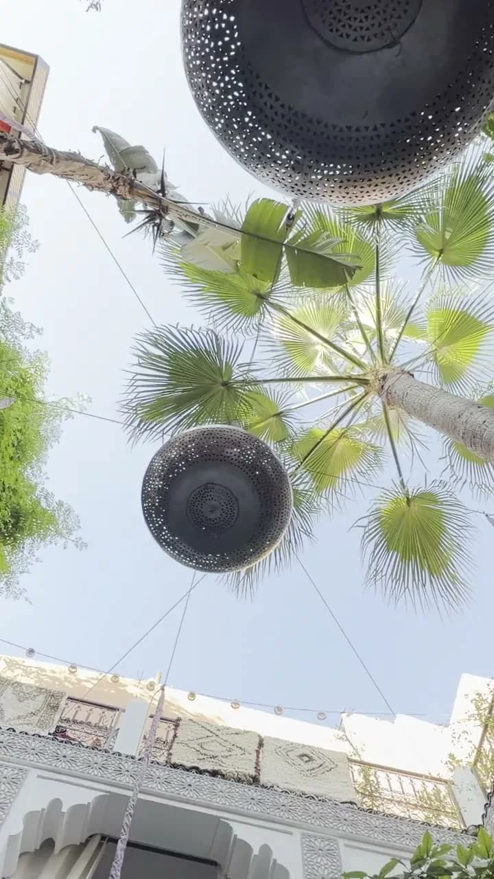 Palmiers et lanternes suspendues au-dessus du patio du Riad O’Zeen à Marrakech