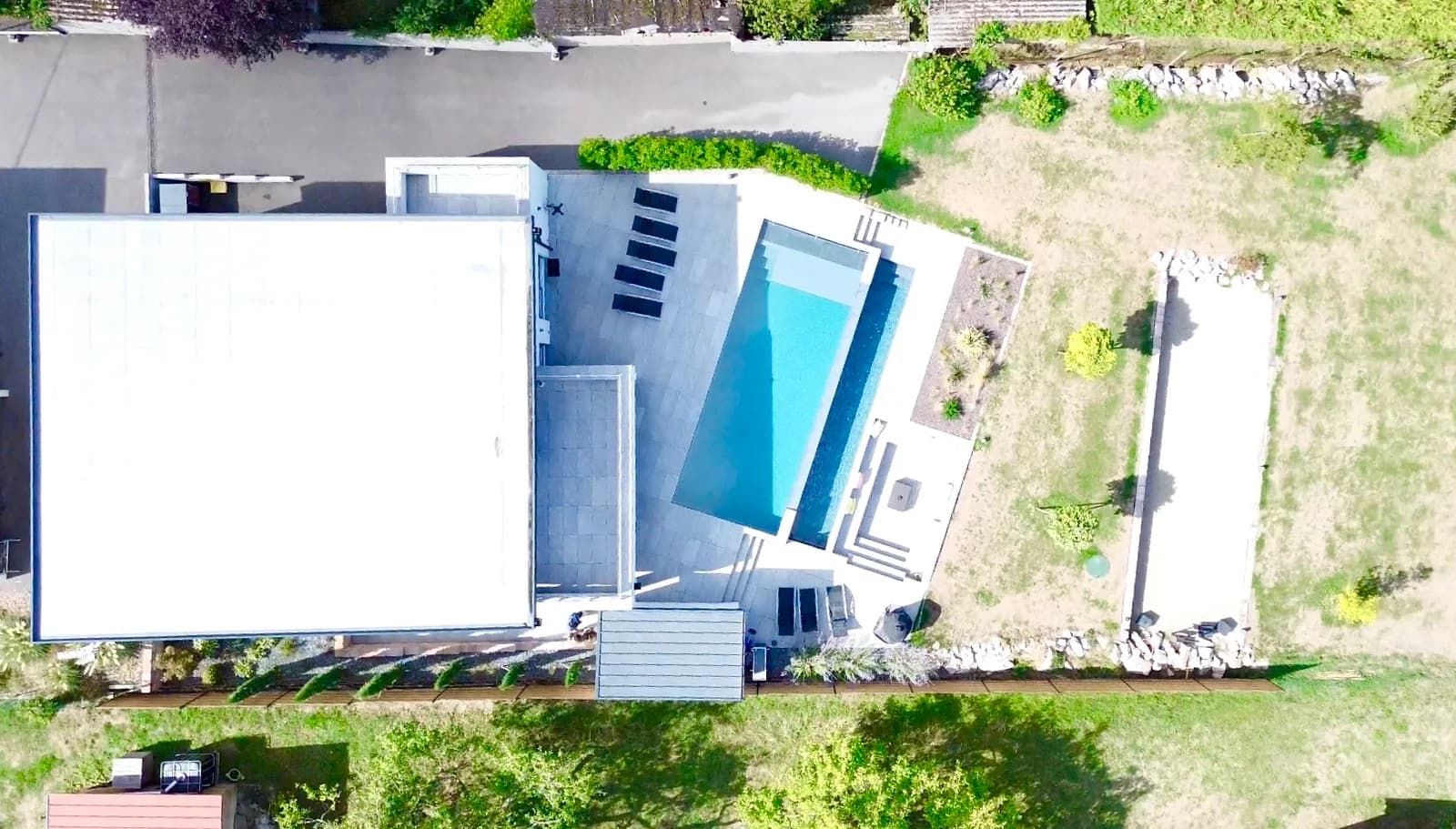 Vue drone de la villa de Dettwiller : toit plat, piscine à débordement, terrasse et jardin